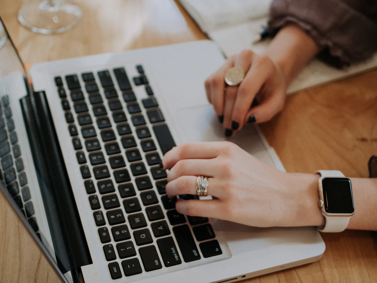 Persoană care lucrează pe un MacBook la optimizarea SEO on page a unui site