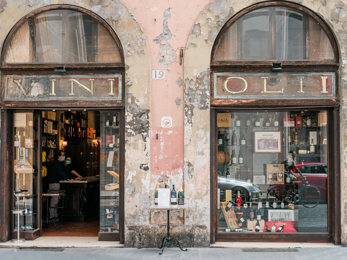 Clădire istorică maro cu alb dintr-un oraș italian, cu ferestre înalte și obloane
