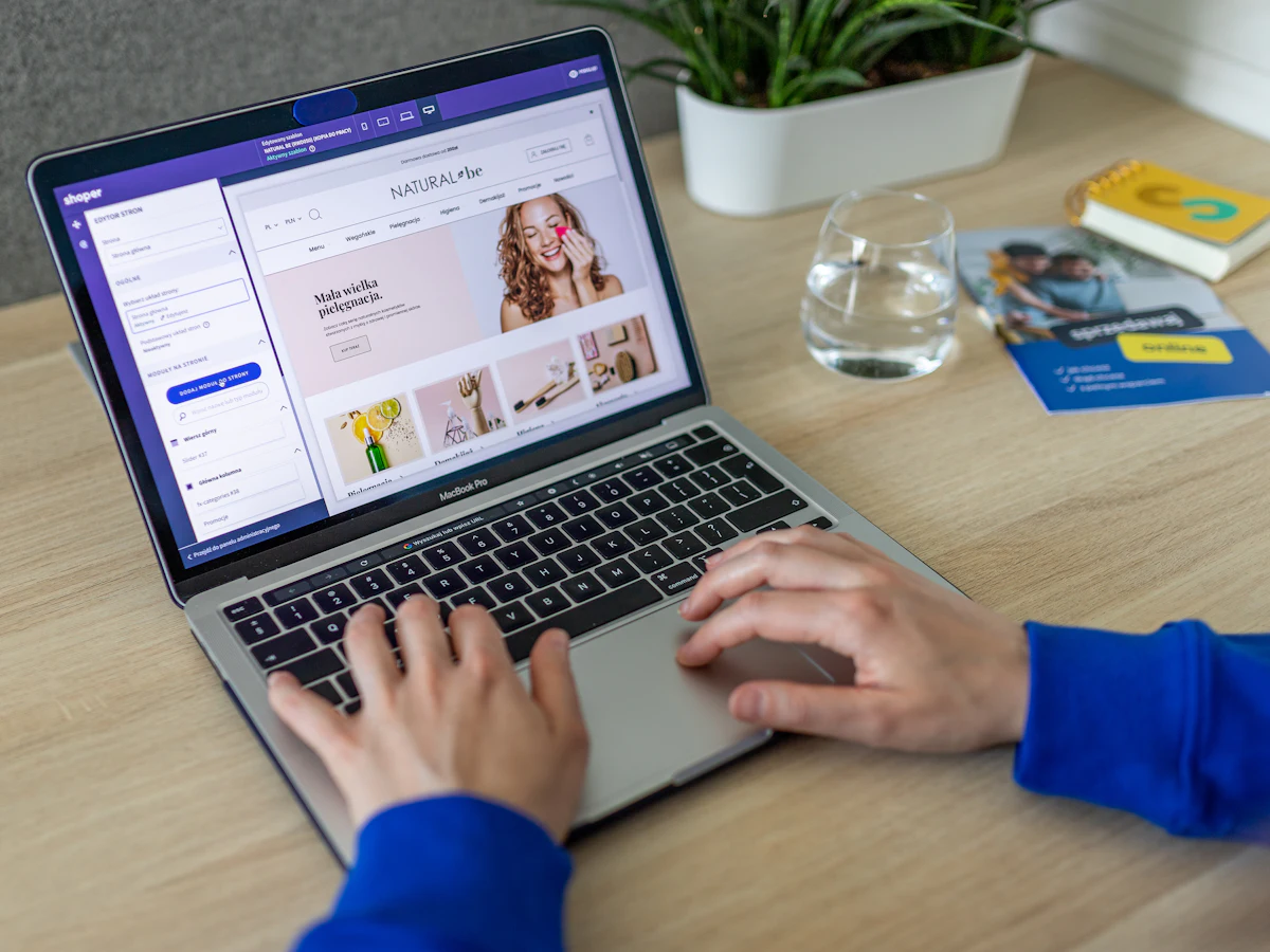 Persoană care tastează la un laptop, lucrând la un site